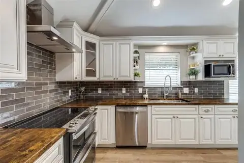 Finished kitchen with white shaker cabinetry, subway tile backsplash and stainless appliances