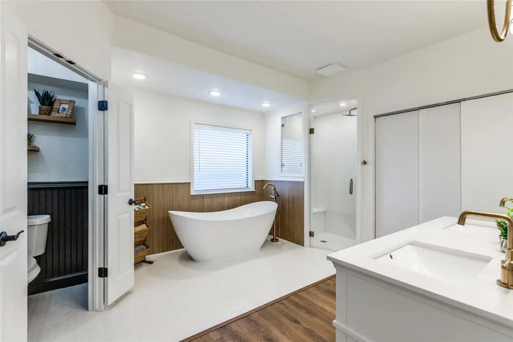 Completed primary bathroom renovation with a freestanding soaking tub, glass shower enclosure and double vanity